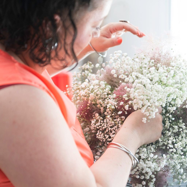 kelly, wedding planner près de Toulouse (31), met en place de beaux bouquets de fleurs dans une salle de réception pour un mariage à Seysses en Haute-Garonne 31
